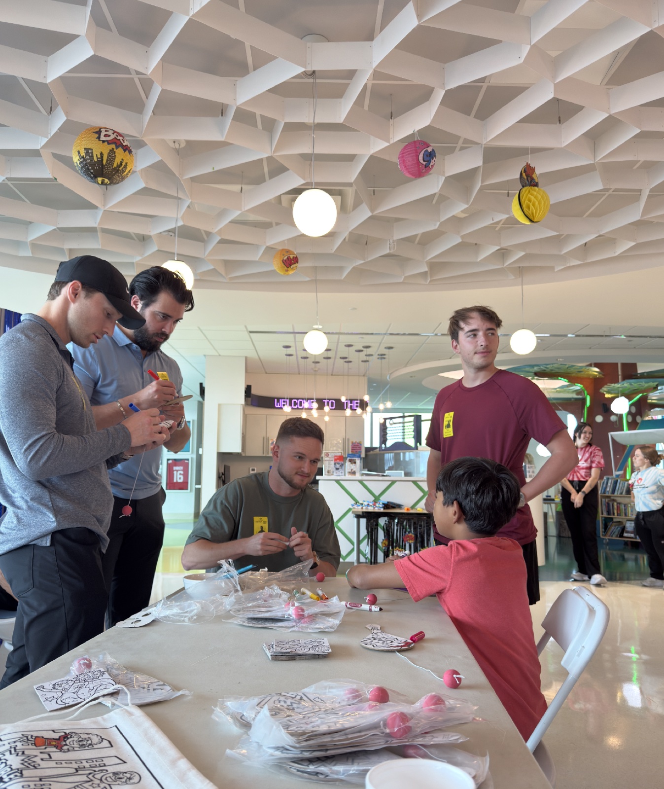 Dawson Gant volunteering at a youth mentorship event, seated at a table with children doing arts and crafts